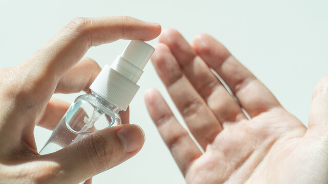 A female hands spraying an antibacterial sanitizer spray for killing disease, bacteria, virus and Coronavirus or Covid-19. Dispenser infection control concept.