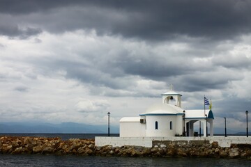 A church next to the sea under a cloudy sky