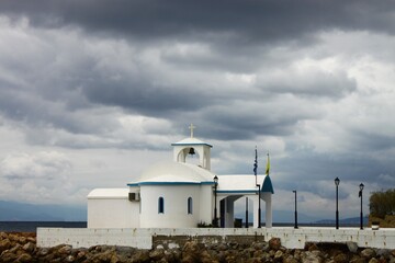 A church next to the sea under a cloudy sky