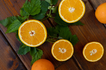 cut oranges on a brown wooden background, top view, text space, citrus fruits