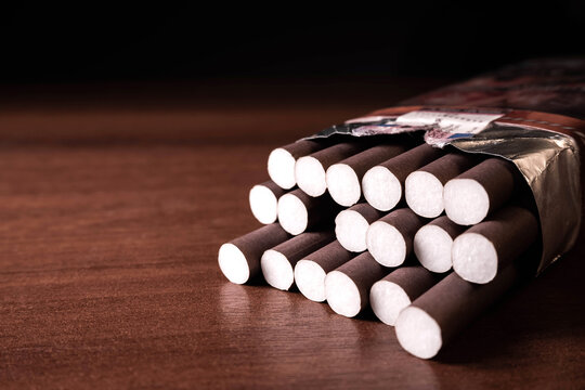 Brown cigarillos on a wood black background