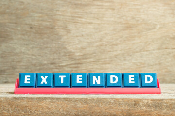 Obraz premium Tile letter on red rack in word extended on wood background