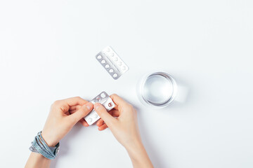 Young woman takes pills, top view female hands