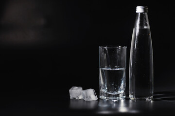 Close up pouring purified fresh drink water from the bottle on table in living room. Drinking water. Mineral vitamin water. Healthy, mineral-rich, refreshing water.