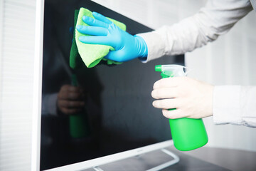 House cleaning concept. Wipe dust off surfaces. Disinfectant treatment of door handles TV electrical. Sanitary treatment at home in quarantine.