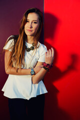 Portrait of pretty young woman posing on colored wall background while looking to the camera, stylish teenager girl posing on bright background, filtered image