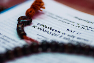 A text from Hindu sacred book Bhagavad Gita along with rosary.