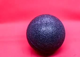 lack fascia ball on a red background. Massage ball made of polystyrene for fascial release