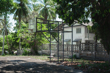 Old rustic grunge basketball hoop in the wild green tropical forest environment. School playground neighborhood