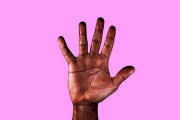 Open palm of a black man with spread fingers asking for stop racism isolated on pink background.