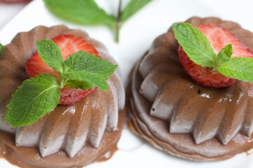Chocolate fudge garnished with half a strawberry with petals. Garnished with sprigs of mint and...