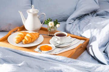 Breakfast in bed, a tray of coffee, french croissants, jam. Honeymoon.  Sunnny morning at the hotel.
