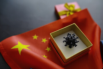The concept of the world coronavirus pandemic. The geographical location of the virus. China flag and virus model and gift box.