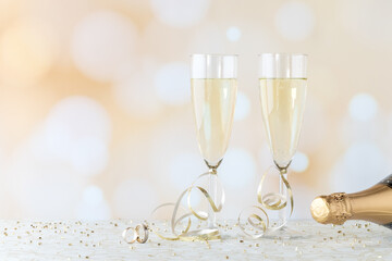 Two flute glasses filled with champagne and wedding bands in front. A Wedding or Anniversary concept. © Carey