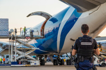 Déchargement d'un avion cargo médical sous la surveillance des forces de l'ordre de la...