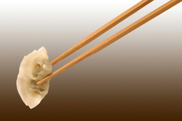 젓가락으로 찐만두를 집다.