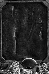 Dismantled horn in a case. Imprints of a musical instrument on a velvet cover. Abstract composition, background. Black and white photography