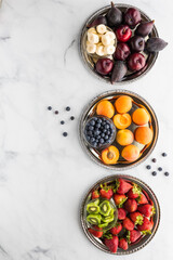 Delicious fruit in complimentary colours on metal trays in a row. A complimentary colour concept.