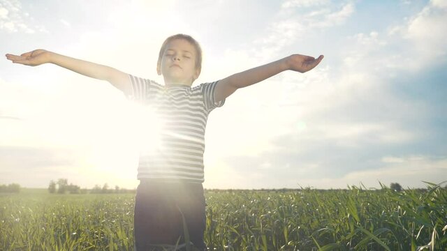 boy prays pulls hands to the sky against a blue sky. child concept faith religion and happy family. lifestyle kid son hands to the side against the blue sky jew praying to god. worship and gratitude