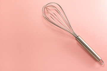 Steel whisk on the right from above. Flat lay top view. Confectionery cooking concept with copy...