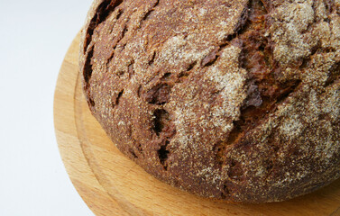 rye, freshly prepared bread on a wooden board, on a white background. Homemade cakes, cooking, organic foods. The texture of rye bread. Bakery Friendly welcome, pastry shop