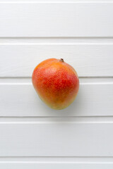 Appetizing ripe juicy Brazilian mango fruit from the tropics on a white wooden background with place for text. Exotic fresh fruits. vitamins and healthy nutrition healthy lifestyle