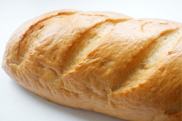 A loaf of fresh white bread, with a crust, on a light background. Bread texture, homemade cakes, cooking, breakfast, bakery. Rise in price, raise food prices