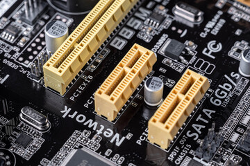 PCI-Express slots and other electronic components on a black motherboard