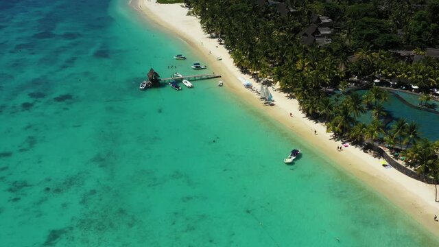 Beach along the waterfront and coral reef and palm trees, Mauritius, Africa, Pier near the beach of the island of Mauritius