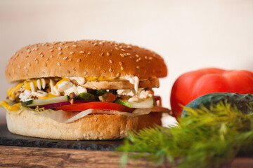 big vegetarian burger and vegetables on a black stone board