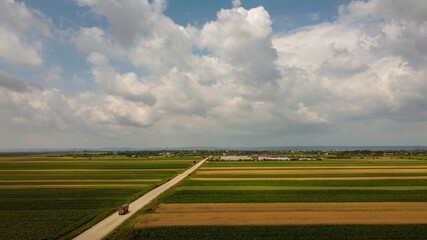 Storm above a agricultural plain  country road