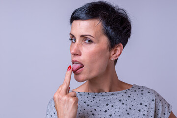 Attractive woman licking the middle finger