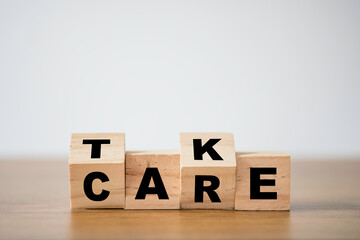 Flipping of take care yourself wording which print screen on wooden cubes blocks on table.