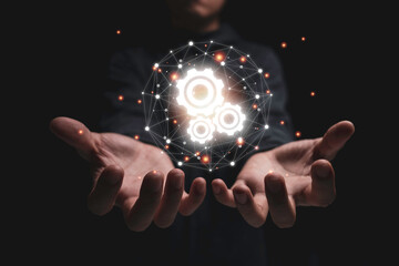 Two hand hold group of virtual cog gears wheel with connection and black background. It is symbol...