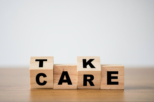 Flipping of take care yourself wording which print screen on wooden cubes blocks on table.