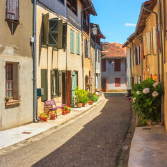 Fototapeta premium Summer city landscape - view of a medieval street in a provincial French town, in the historical province Gascony, the region of Occitanie of southwestern France