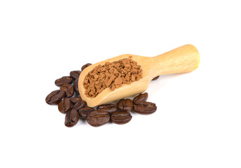 freeze dried instant coffee in wooden spoon and roasted coffee beans on white background