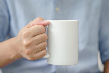 Mug mockup. businessman's hands holding mug with blank space for your text or promotional content.