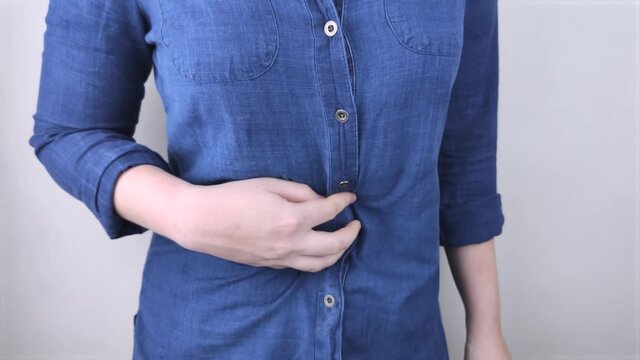 A woman holds on to his stomach. Pain in the abdominal cavity. The concept of diseases of the stomach and digestive system