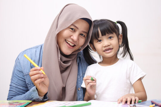Asian muslim mother drawing with her daughter, single mom teaching baby girl, happy family