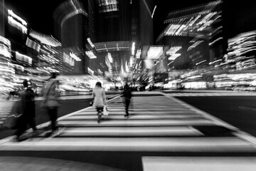 Pedestrians crossing the street at the heart of Ginza District in Tokyo. Ginza crossing at night. Blurred motion.