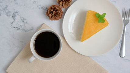 Orange cake and coffee on white mable background. Top view