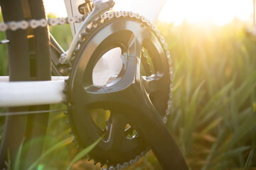 Drive train of a bike with a sunrise/ sunset background. Crankshaft.