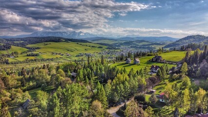 Fototapeta na wymiar Tatra mountains visible behind a forest and a small village in Poland, Europe
