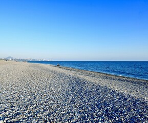 sea coast with pebble beach and city