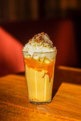 Refreshing and stimulating iced coffee with whipped cream and nuts