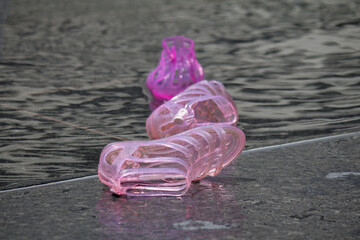 Pink jelly shoes lay discarded by the fountains in Philadelphia's Dilworth Park on a late spring day.