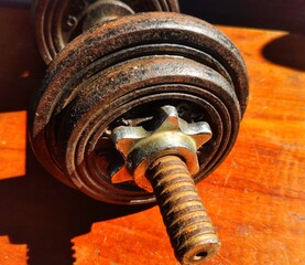 Old rusty dumbell on a wooden floor