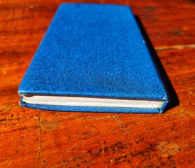 Blue colour note book on Wooden floor