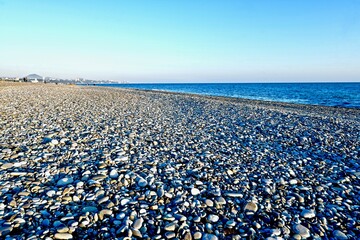 sea coast with pebble beach and city